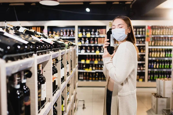 Woman Medical Mask Holding Wine Bottle Supermarket — Stock Photo, Image