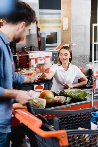 Mosolygós Pénztáros Vesz Hitelkártyát Ügyfél Közelében Élelmiszer Szupermarket Pénztár — Stock Fotó