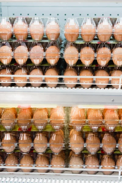 Eggs in plastic trays on shelves in supermarket