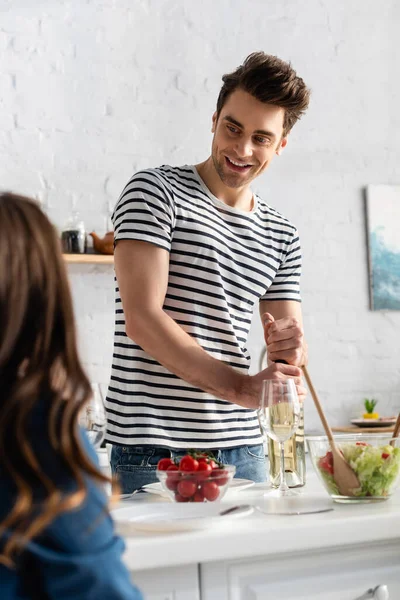 Glad Man Öppna Flaska Vin Nära Kvinna Suddig Förgrund — Stockfoto