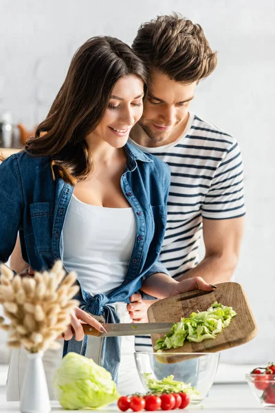 Casal Alegre Preparando Salada Cozinha Com Guardanapos Primeiro Plano Borrado — Fotografia de Stock