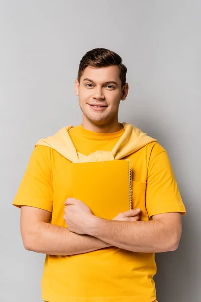 Estudiante Alegre Ropa Amarilla Sosteniendo Cuaderno Sobre Fondo Gris — Foto de Stock