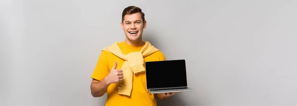 Man Holding Laptop Blank Screen Showing Thumb Grey Background Banner — Stock Photo, Image