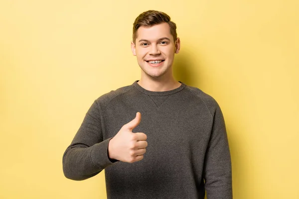 Glimlachende Man Toont Als Teken Gele Achtergrond — Stockfoto