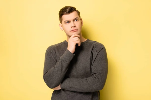 Pensive Man Grey Pullover Looking Camera Yellow Background — Stock Photo, Image