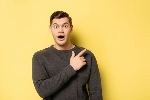 Excited Man Looking Camera Pointing Finger Yellow Background — Stock Photo, Image