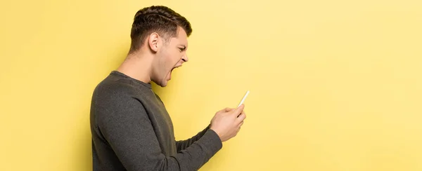 Vista Lateral Homem Com Raiva Gritando Usar Smartphone Fundo Amarelo — Fotografia de Stock