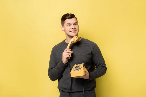 Sorrindo Homem Segurando Telefone Retro Fundo Amarelo — Fotografia de Stock