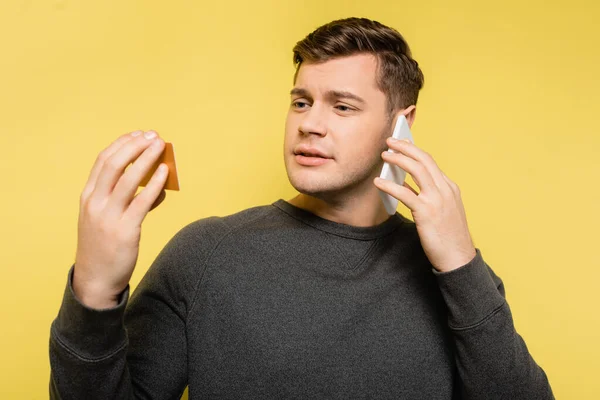 Man Talking Telephone Looking Credit Card Yellow Background — Stock Photo, Image