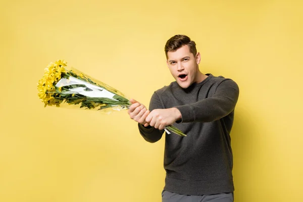 Spännande Man Som Håller Bukett Gul Bakgrund — Stockfoto