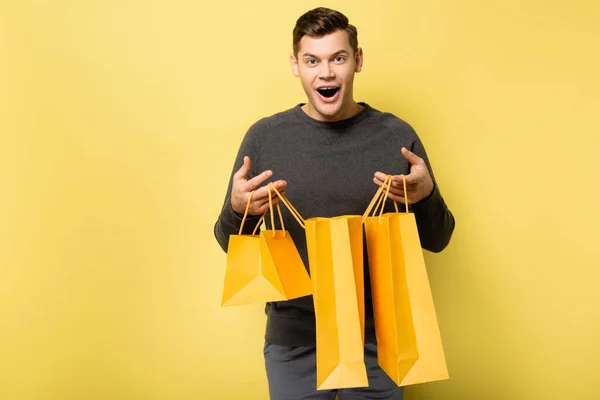 Excited Man Holding Shopping Bags Yellow Background — Stock Photo, Image