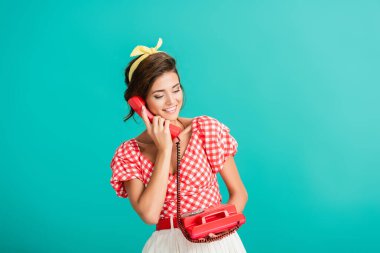 happy pin up woman talking on retro phone isolated on turquoise clipart