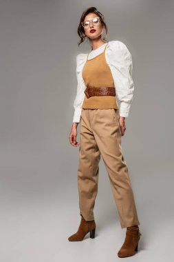 Gri renkte poz veren modaya uygun retro elbiseli kadın manzarası.