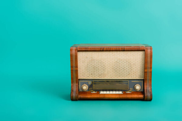 vintage wooden radio receiver on turquoise background