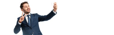 Gülümseyen iş adamı selfie çekiyor ve zafer jestini beyaz pankartta izole ediyor.