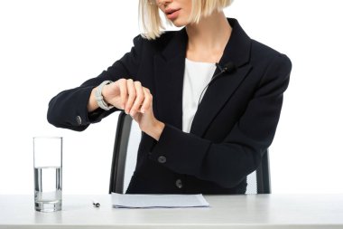 Kırpılmış haber spikeri görüntüsü, iş yerindeki kol saatini kontrol ediyor, beyaz üzerinde izole edilmiş.