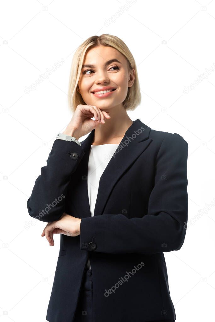 cheerful businesswoman with hand near chin looking away isolated on white