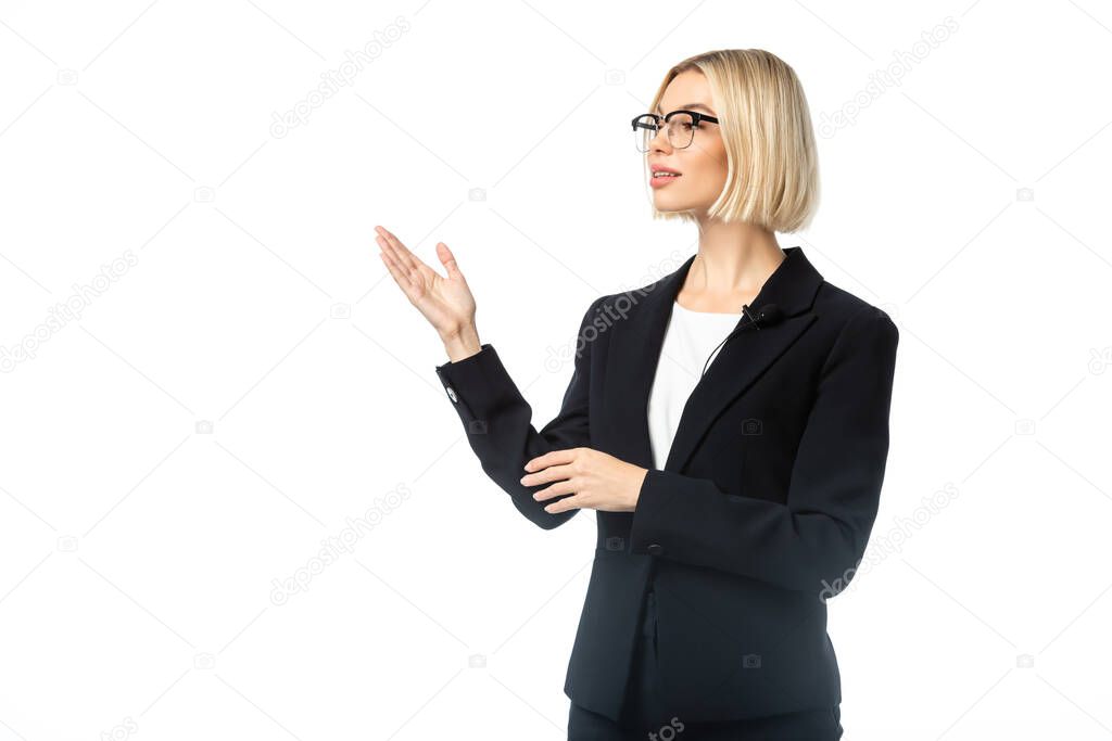 blonde businesswoman looking away and pointing with hand isolated on white