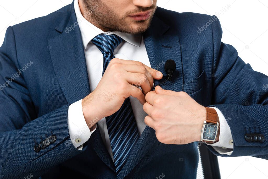cropped view of news anchor fixing microphone to blazer isolated on white