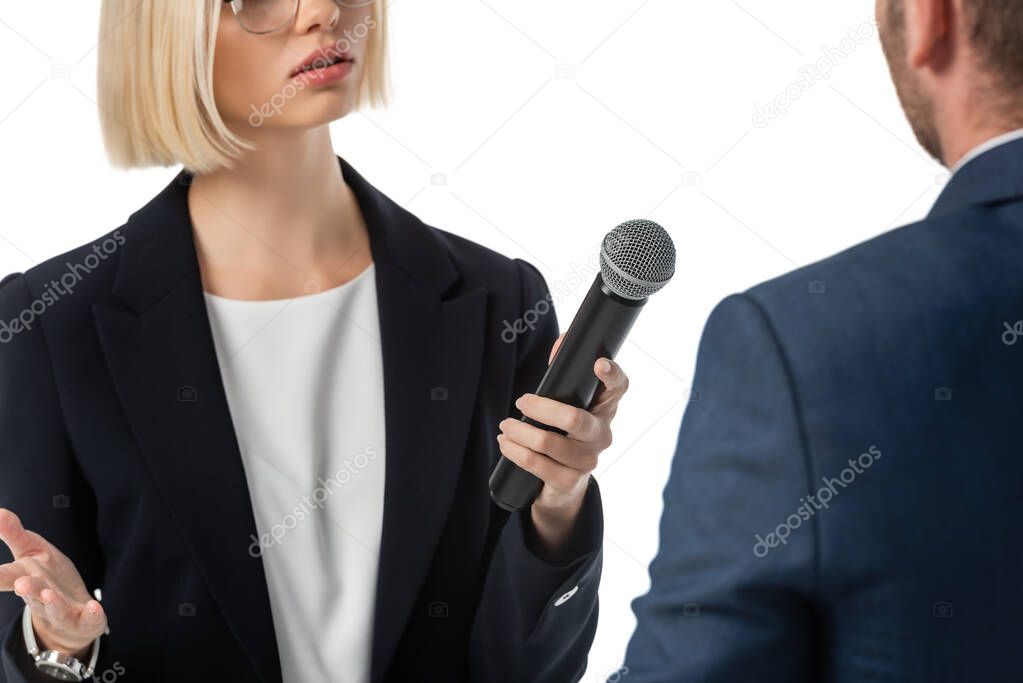 cropped view of young news anchor taking interview from businessman isolated on white, blurred foreground