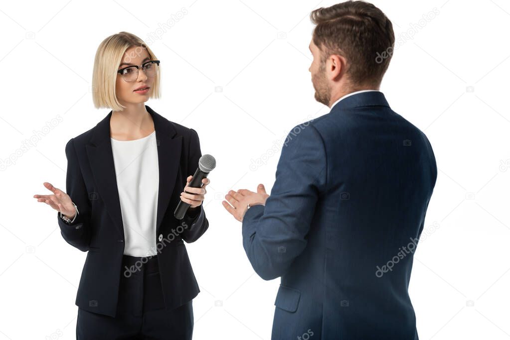 blonde journalist gesturing while interviewing businessman isolated on white