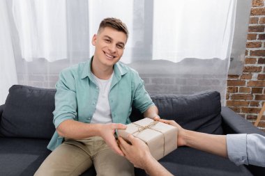 happy homosexual man receiving valentines present from husband  clipart