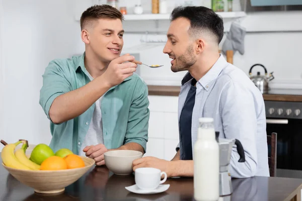 Homosexual Hombre Alimentación Marido Con Maíz Copos Cerca Taza Frutas — Foto de Stock