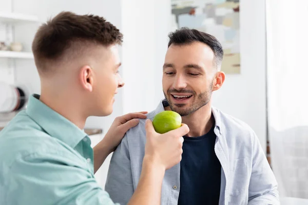 Happy Homosexual Man Feeding Husband Green Apple — Stock Photo, Image