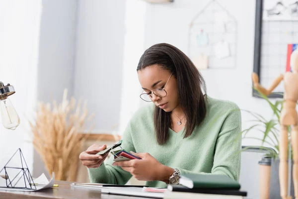 African American Interior Designer Choosing Color Material Blurred Foreground — Stock Photo, Image