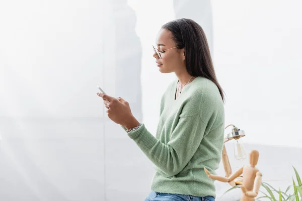 African American Interior Designer Messaging Smartphone Wooden Human Figurine — Stock Photo, Image