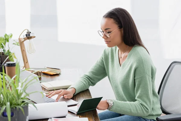 African American Architect Typing Laptop Notebook Green Plant Blurred Foreground — Stock Photo, Image