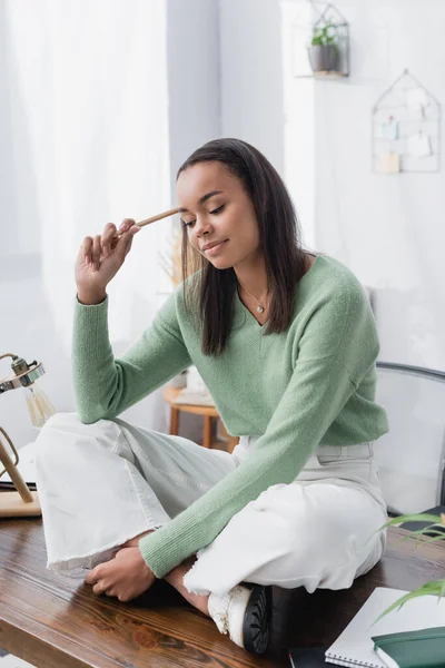 Diseñador Interiores Afroamericano Positivo Sosteniendo Lápiz Mientras Está Sentado Escritorio — Foto de Stock