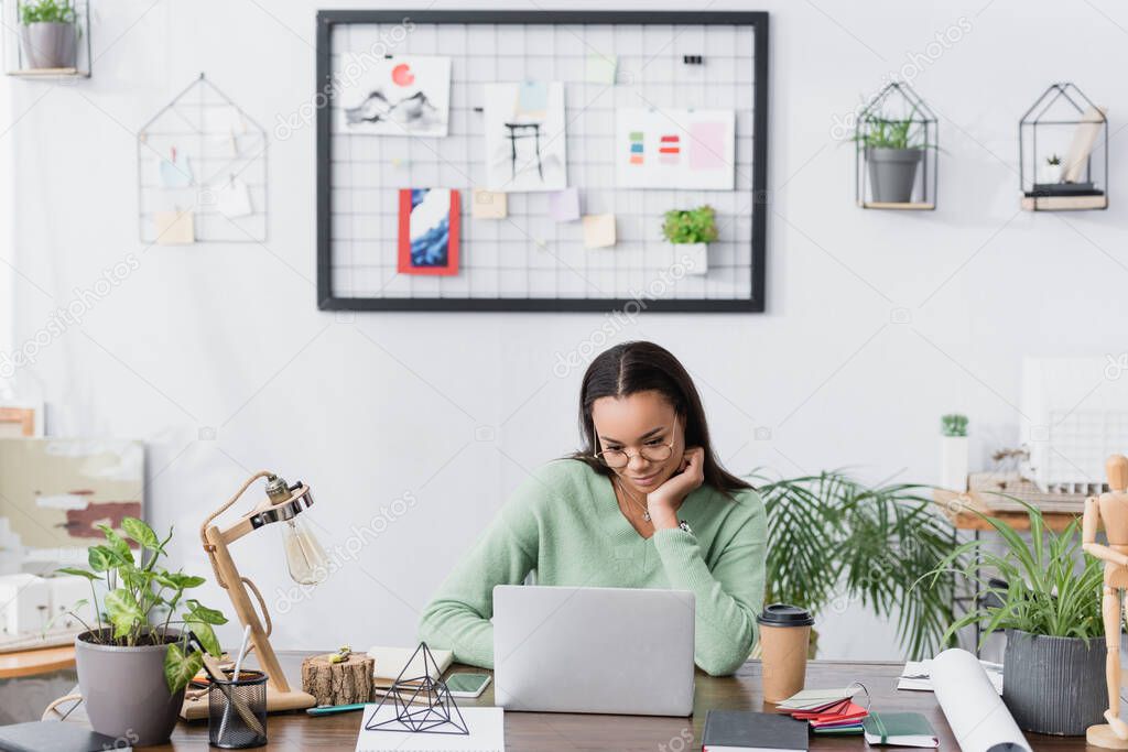 young african american interior designer working near laptop at home studio