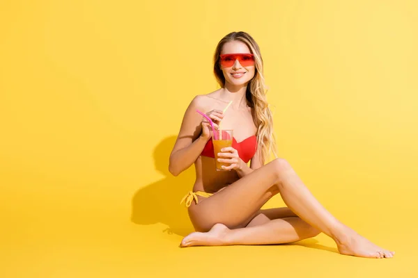 Çıplak Ayaklı Güneş Gözlüklü Kameraya Gülümseyen Kadın Sarıda Ferahlatıcı Bir — Stok fotoğraf