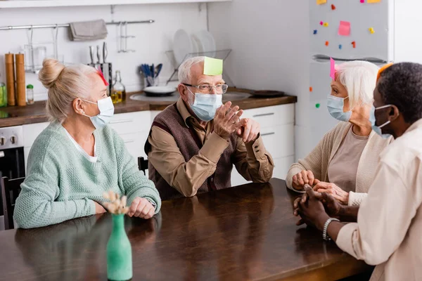 Personas Jubiladas Máscaras Médicas Con Notas Adhesivas Frente Jugando Juegos —  Fotos de Stock