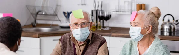 Retired Man Medical Mask Sticky Note Forehead Looking Camera While — Stock Photo, Image