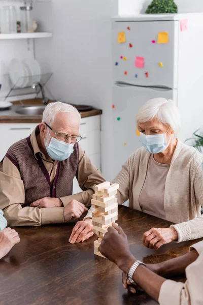 Pessoas Multiculturais Seniores Máscaras Médicas Jogando Torre Blocos Madeira Jogo — Fotografia de Stock