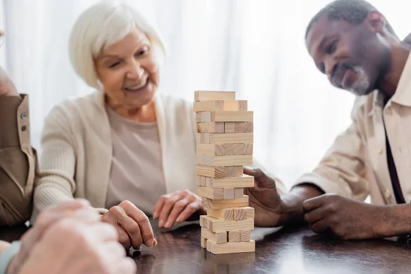 Tower Wood Blocks Table Happy Multicultural Pensioners Blurred Background — Stock Photo, Image