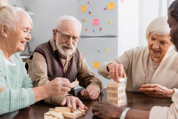 Happy Interracial Pensioners Smiling While Playing Tower Wood Blocks Game — Stock Photo, Image