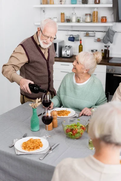 Senior Man Eyeglasses Pouring Red Wine Glass Happy Friends — Stock Photo, Image