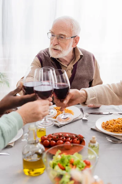 Uomo Anziano Occhiali Brindare Con Amici Multiculturali Durante Pranzo — Foto Stock