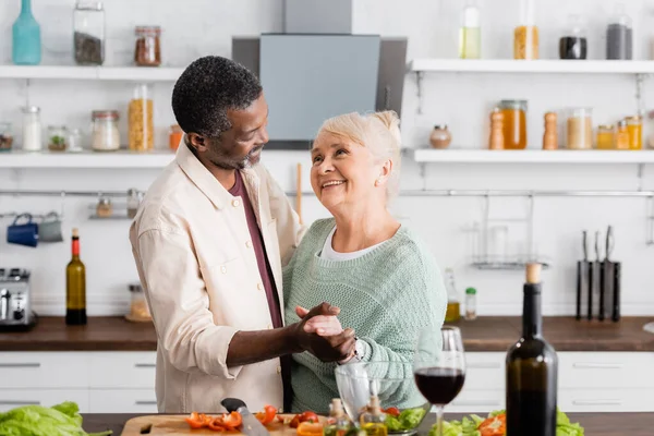 Senior Interracial Husband Wife Smiling While Holding Hands Kitchen — Stock Photo, Image