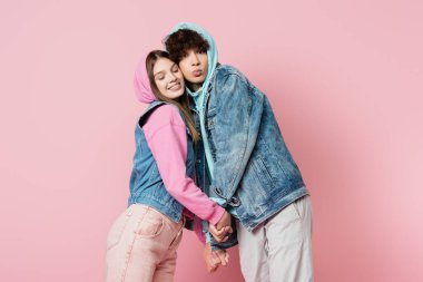 Teen couple holding hands isolated on pink clipart