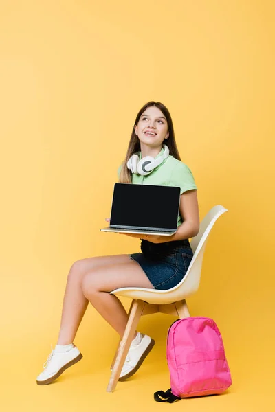 Leende Tonåring Med Bärbar Dator Hörlurar Och Ryggsäck Sitter Stol — Stockfoto