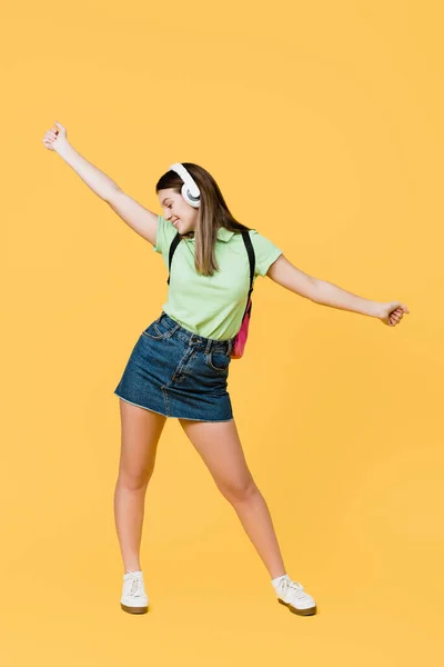 Positief Tiener Meisje Hoofdtelefoon Met Rugzak Dansen Geïsoleerd Geel — Stockfoto