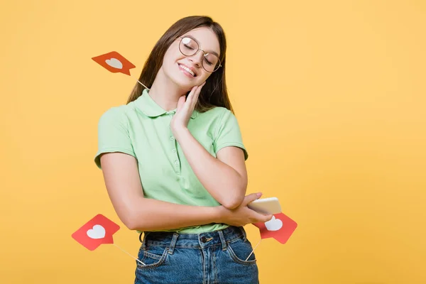 Lachende Tiener Met Papieren Harten Stokken Houden Smartphone Geïsoleerd Geel — Stockfoto