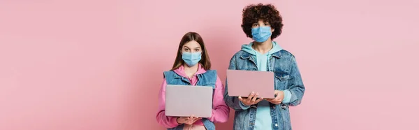 Adolescenti Maschere Protettive Che Tengono Computer Portatili Sfondo Rosa Banner — Foto Stock