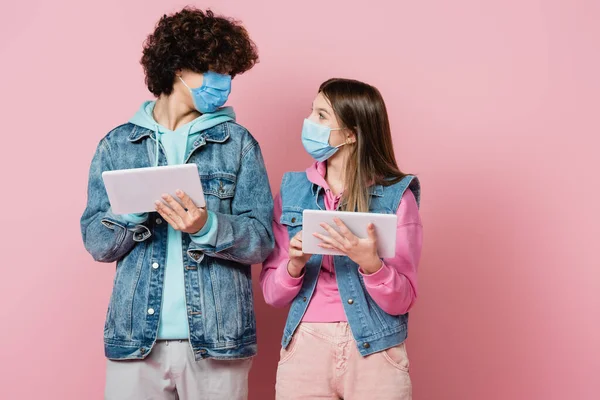 Koruyucu Maskeli Genç Kız Elinde Dijital Tabletle Pembe Arka Plandaki — Stok fotoğraf