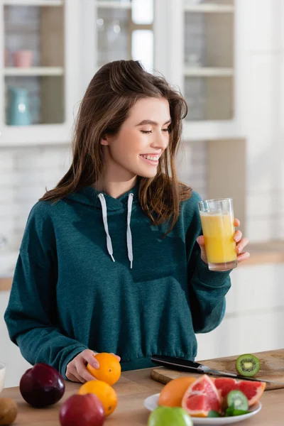 Mulher Alegre Segurando Smoothie Fresco Perto Frutas Balcão Cozinha — Fotografia de Stock