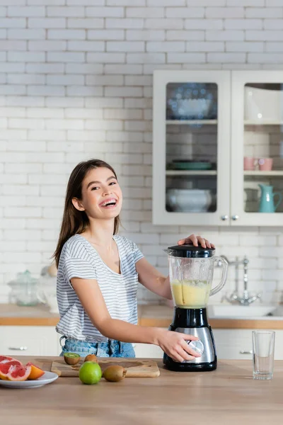 Skrattande Kvinna Tittar Kameran Medan Förbereder Frukt Smoothie Köket — Stockfoto